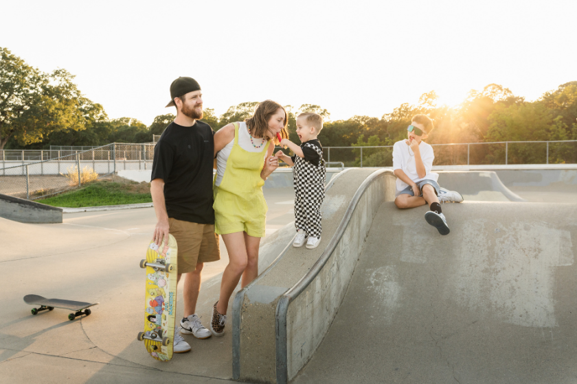 Rocklin Skatepark family portrait session, mom in yellow overalls eating popsicles at sunset
